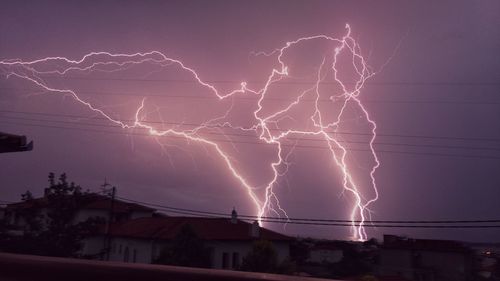 Lightning over city against sky at night