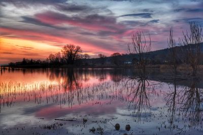 Scenic view of lake against sky at sunset