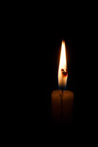 Close-up of illuminated candle in darkroom