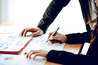 Midsection of business people working at table