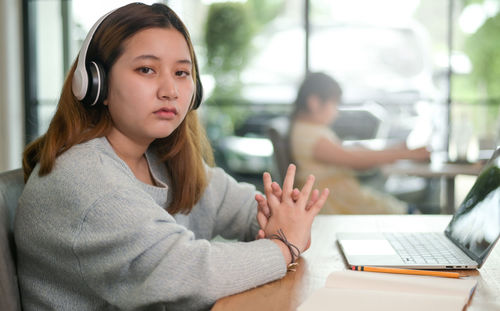 Female student resting while using laptop to study online.