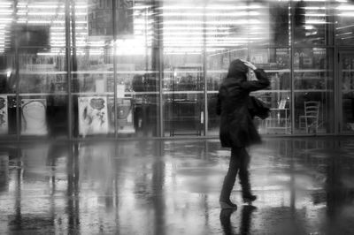 Full length of man photographing reflection on mirror