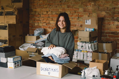 Volunteer teengirl preparing donation boxes for people.