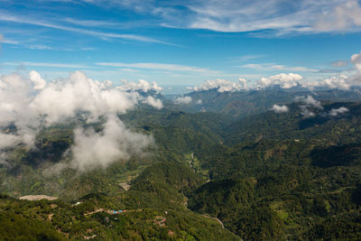 Mountains covered rainforest, trees and blue sky with clouds. philippines.