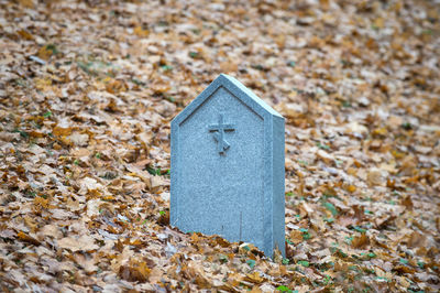 Close-up of stone cross on field