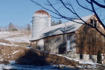 Snow covered buildings against sky during winter