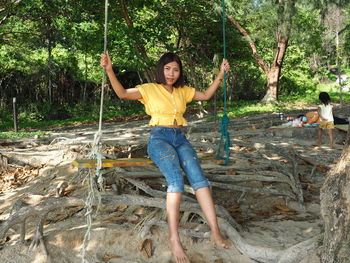 Full length of woman with arms raised in forest