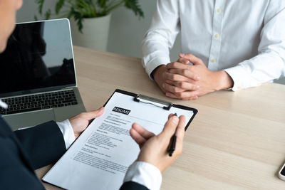 Midsection of man using laptop on table