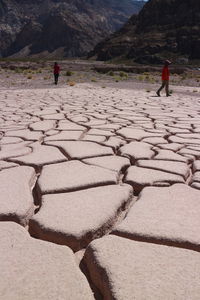 Rear view of people walking on mountain