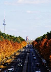 High angle view of cars on road amidst autumn trees against sky