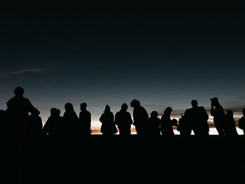 Silhouette of people looking at sky