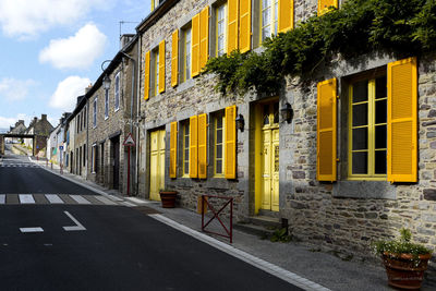 Empty road by buildings in city