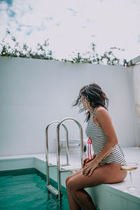 Woman sitting on swimming pool