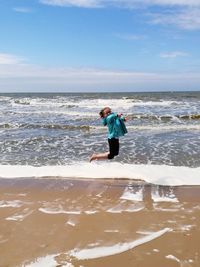 Full length of woman on beach against sky