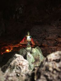 Sculpture of buddha statue on rock at night