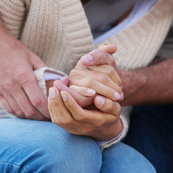 Midsection of couple holding hands