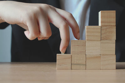 Close-up of hand with toy blocks on table