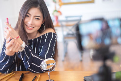 Portrait of a smiling young woman sitting at table