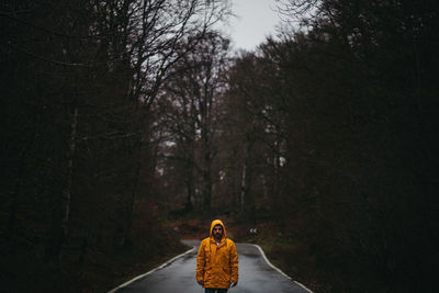 Rear view of woman on road in forest during winter