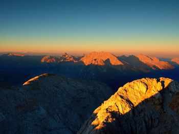 Morning sun on alpine cliff and night in valley bellow. daybreak sun shinning horizon. 