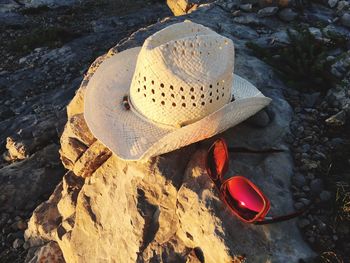 High angle view of sunhat and sunglasses on rock