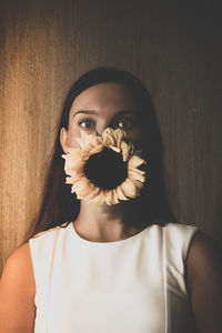 Portrait of woman with sunflower on face