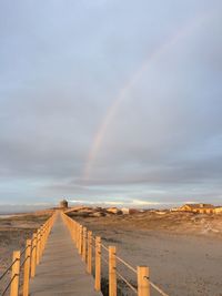 Scenic view of rainbow over sea against sky