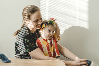 Mother and daughter sitting on sofa