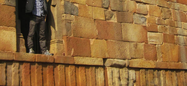 Low section of man standing on brick wall