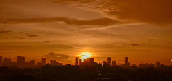 Buildings in city against sky during sunset