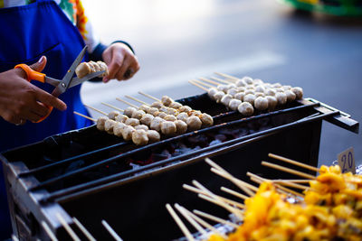 Person preparing food on barbecue grill