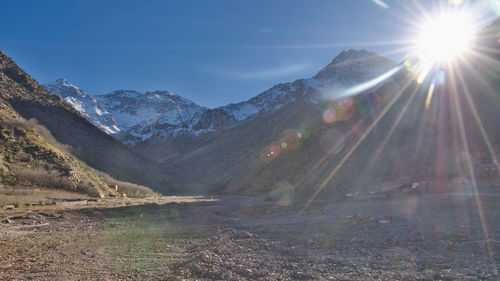 Scenic view of snowcapped mountains against sky on sunny day