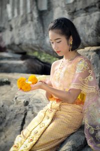 Girl in traditional clothing sitting at park