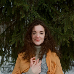 A woman stands on the shore of a frozen lake in a yellow scarf