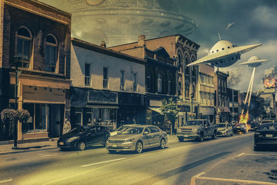 Cars on road by buildings in city against sky