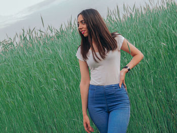 Beautiful young woman standing on field