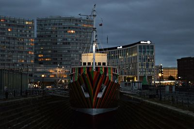 Illuminated modern buildings against sky at night