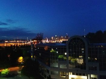 Illuminated cityscape against sky at dusk