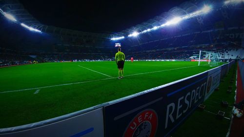 Man playing soccer on field at night