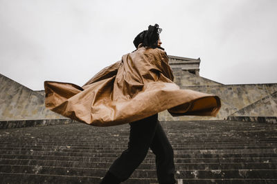 Low angle view of woman standing on staircase against built structure
