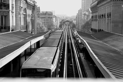 Railroad tracks in city against sky