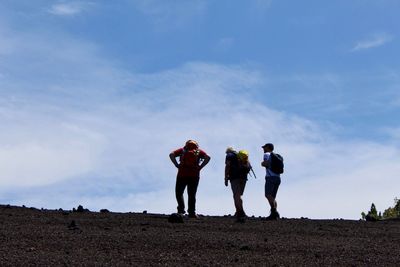 People standing on land against sky