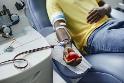 Man holding soft ball and donating blood at center