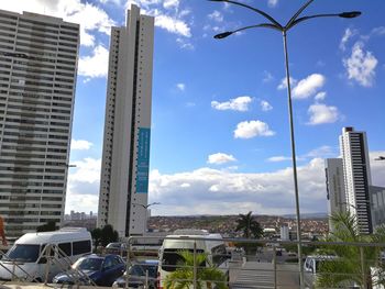 Cars on street by buildings against sky