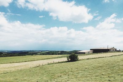 Scenic view of field against cloudy sky