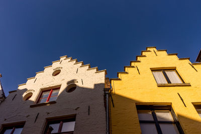 Low angle view of building against clear blue sky