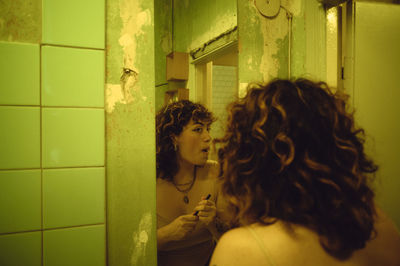 Side view of young woman standing in bathroom