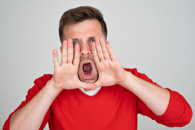 Low section of woman using mobile phone against white background