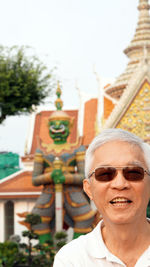 Portrait of man wearing sunglasses against building