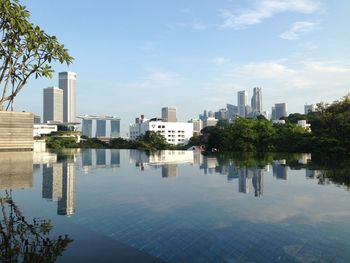 Reflection of buildings in city against sky